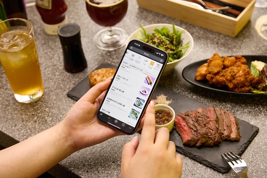 テーブルでスマートフォンから注文する様子